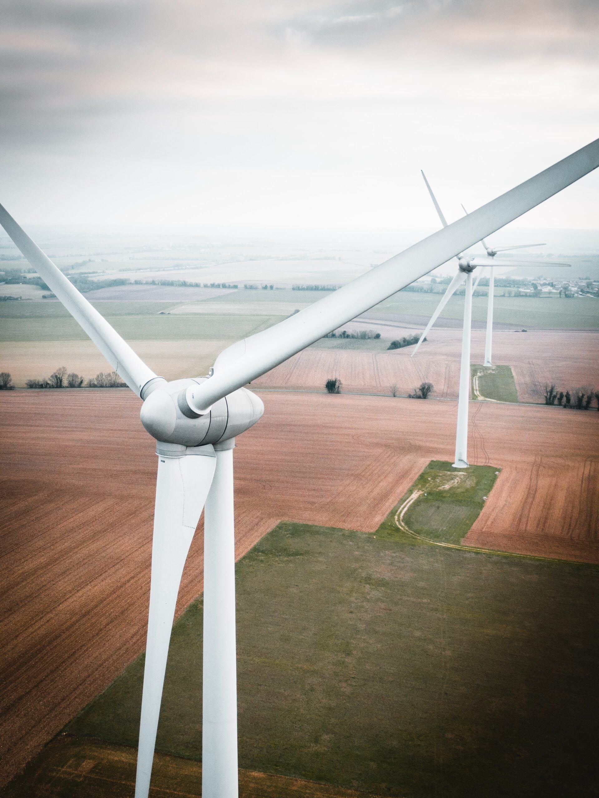 Depicts wind turbines on a farm. Used to represent renewable energy as an asset class.