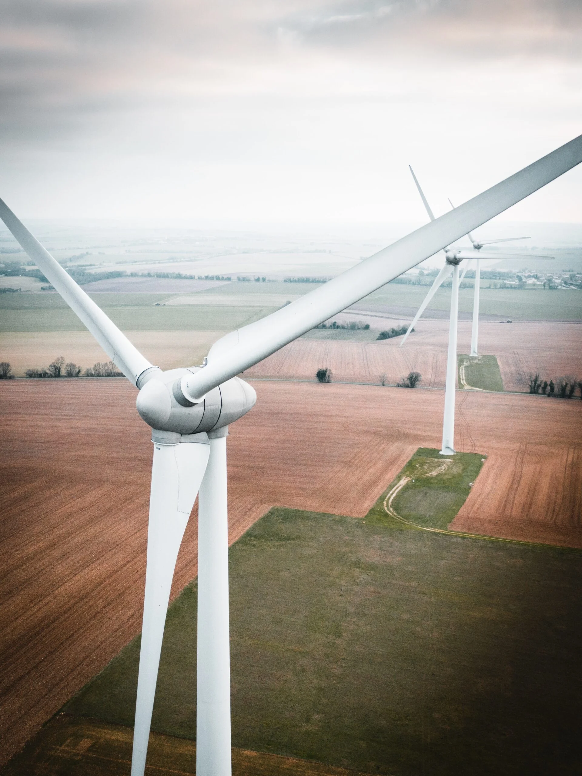 Depicts wind turbines on a farm. Used to represent renewable energy as an asset class.