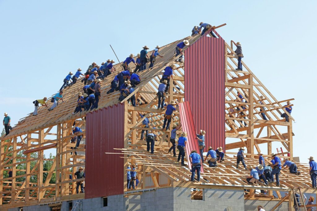 A large group of people assembling a house. Used as a cover image for an article about Groundfloor Labs.