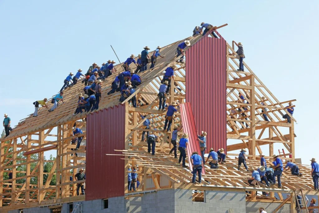 A large group of people assembling a house. Used as a cover image for an article about Groundfloor Labs.