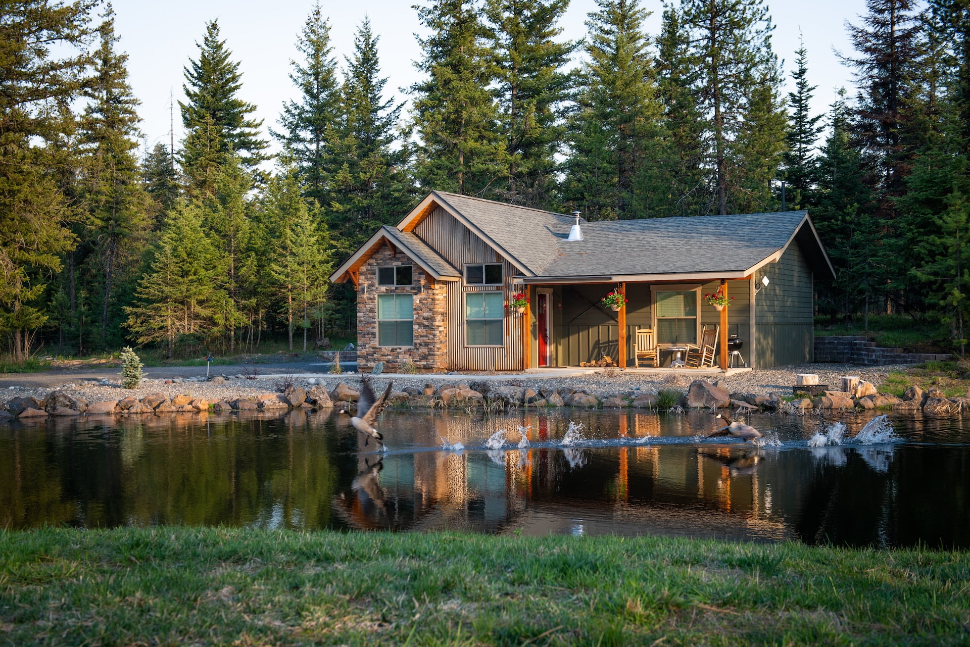 Depicts a large cabin in front of a small pond with geese. Used as a cover image in an overview of Here, the platform for fractional investments in vacation rental homes.