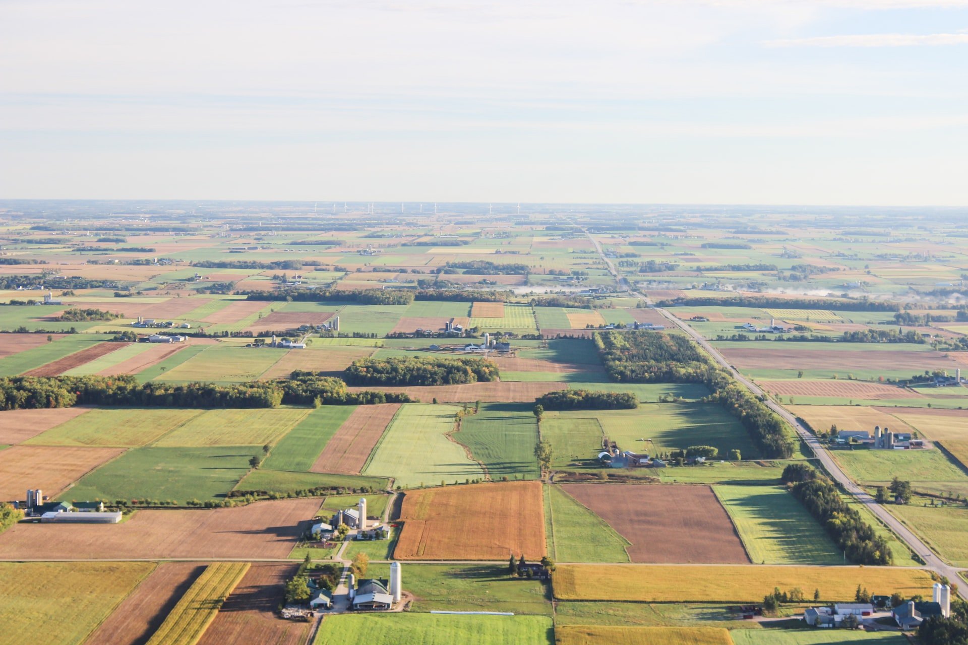 Depicts an arial view of many farms. Used as a cover image for a landing page for farmland as an alternative investment.