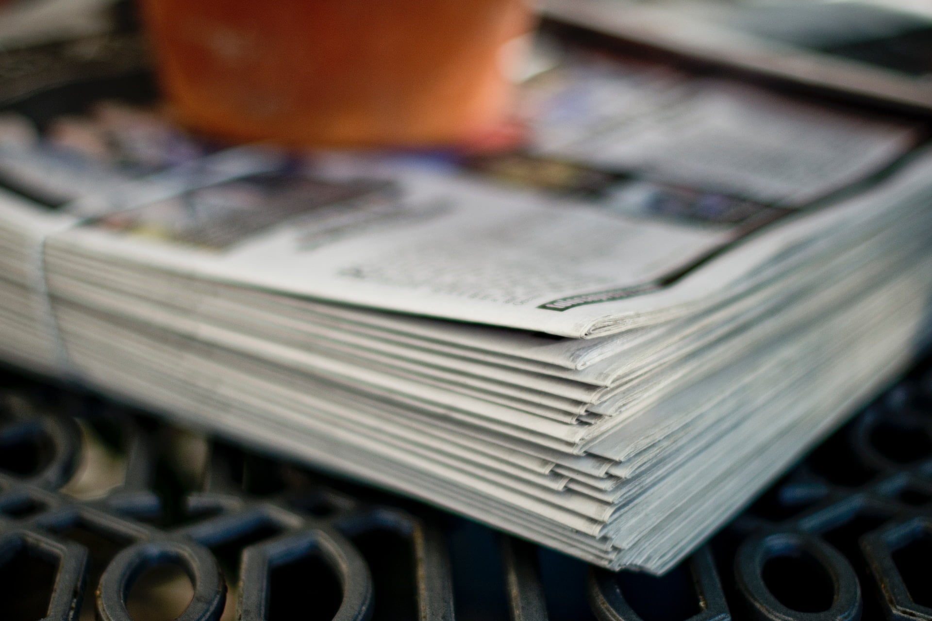 Depicts a pile of newspapers. Used as a cover image for a roundup post about alternative investment news.
