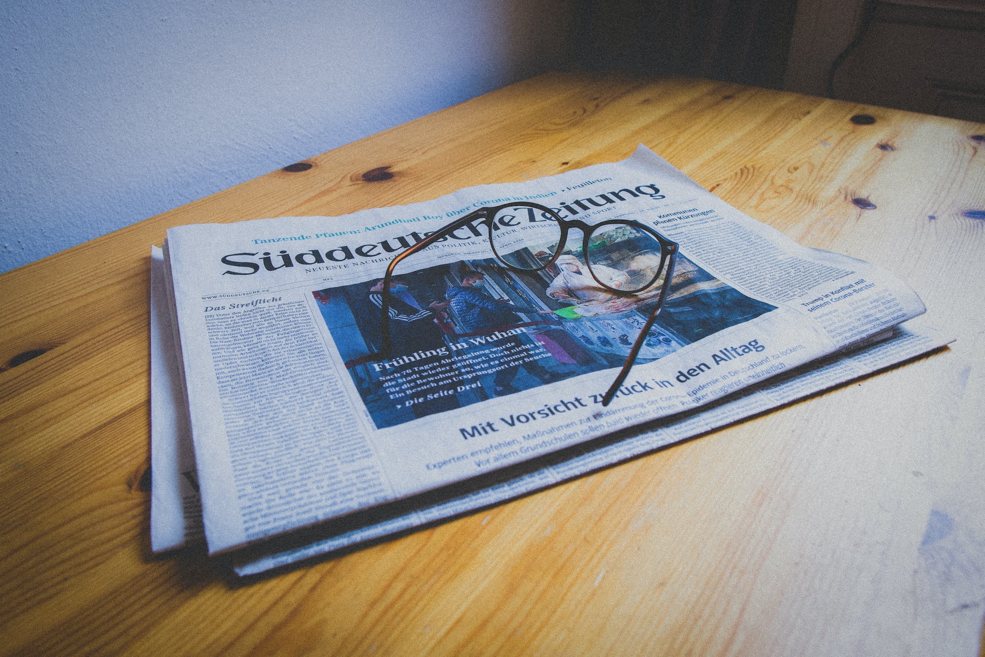Depicts a newspaper on a table near a pair of glasses. Used for a roundup of alternative investment news.