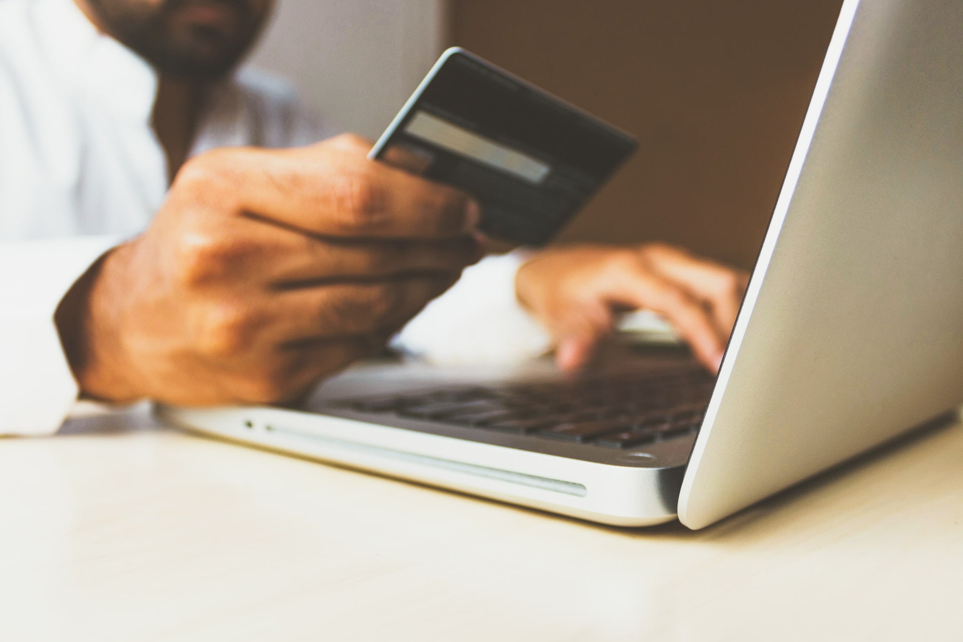 Depicts a man making an online payment. Used as a cover image for an article discussing how to invest in Stripe.